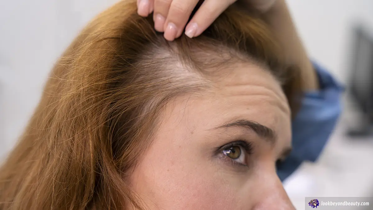 Caucasian woman looking in the mirror wondering why is my hair thinning?